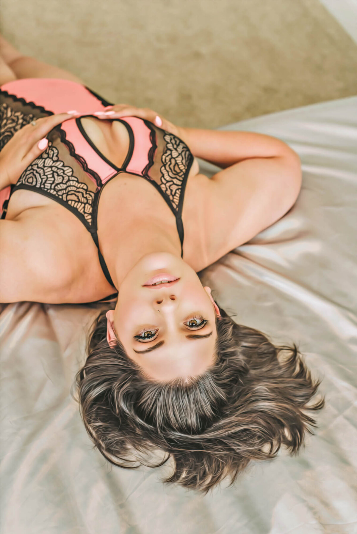 Boudoir client laying on her back on the bed in LeAnn L'Amore's studio in Raleigh North Carolina.